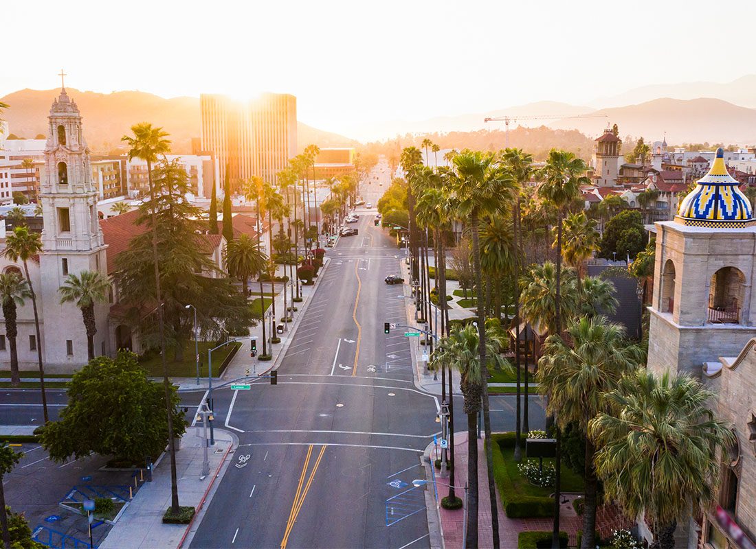 Riverside, CA - Aerial View of a Main Street in Downtown Riverside California Surrounded by Palm Trees and Commercial Buildings at Sunset